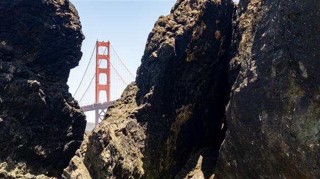 Golden Gate Bridge framed by rocks on Marshall's Beach